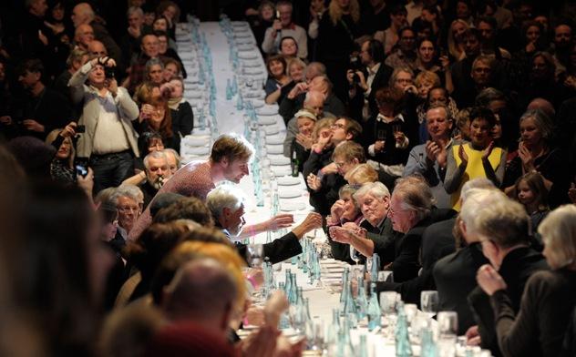 Ein recht feudales Arrangement – Kulturstaatssekretär Tim Renner und Volksbühnen-Intendant Frank Castorf stoßen, vom „Volk“ beklatscht, an langer Tafel auf den 100. Geburtstag der Volksbühne an. Foto Thomas Aurin