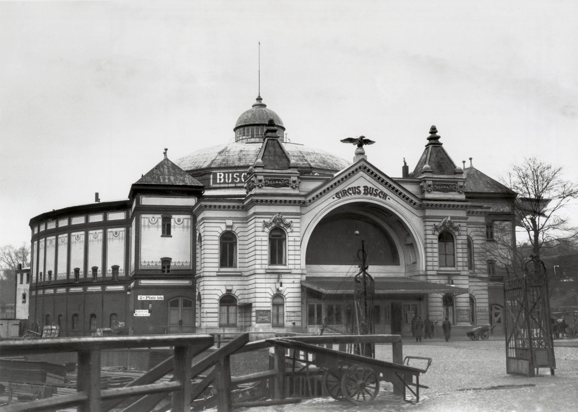 Fotografie von Vorplatz und Eingangsportal von Circus Busch und der Anlegestelle an der Spree links unten (ca. 1900).