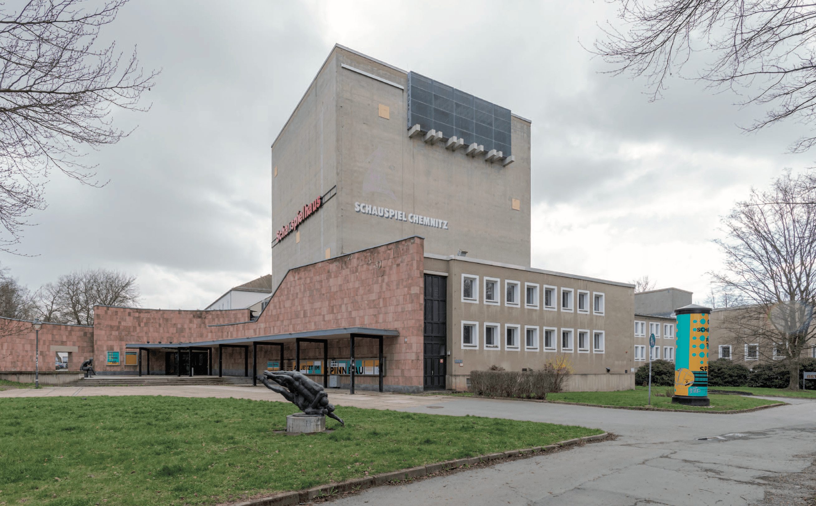Schauspielhaus mit Zuwegung von der Zieschestraße, im Vordergrund die Bronzeskulptur Ringende von Siegfried Krepp, 2023