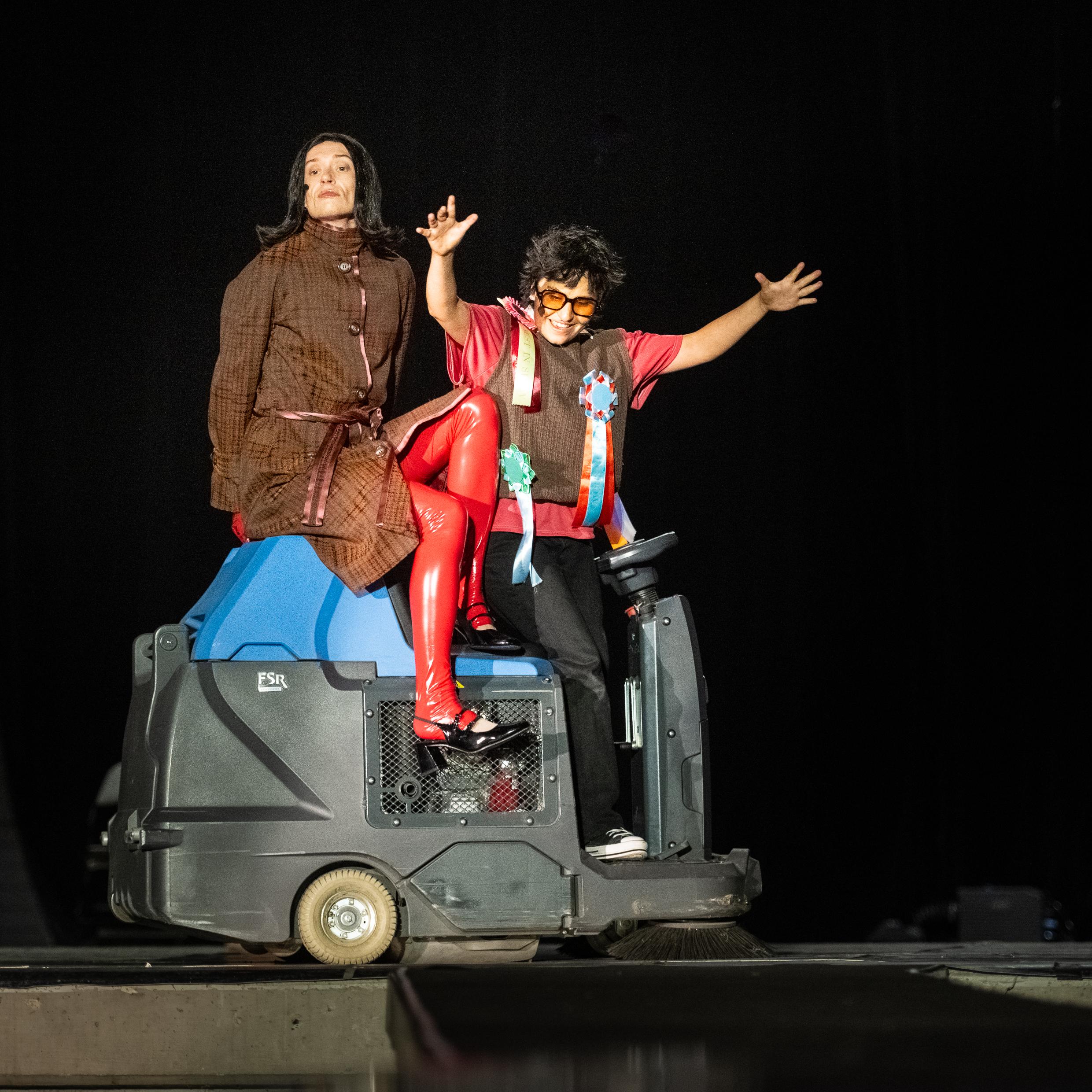 In Hassliebe vereint auf der Kehrmaschine: Jonathan Perleth als Elfriede Jelinek (links) und Saba Hosseini als Regisseur, vermutlich Claus Peymann. Foto Joachim Dette