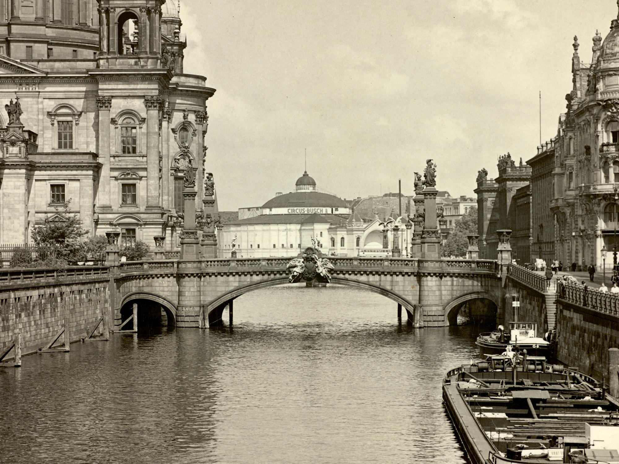 Ausschnitt aus einer Fotografie mit Blick von der Kurfürstenbrücke (heute Rathausbrücke) auf die Spree und das Gebäude von Circus Busch im Hintergrund (ca. 1930).