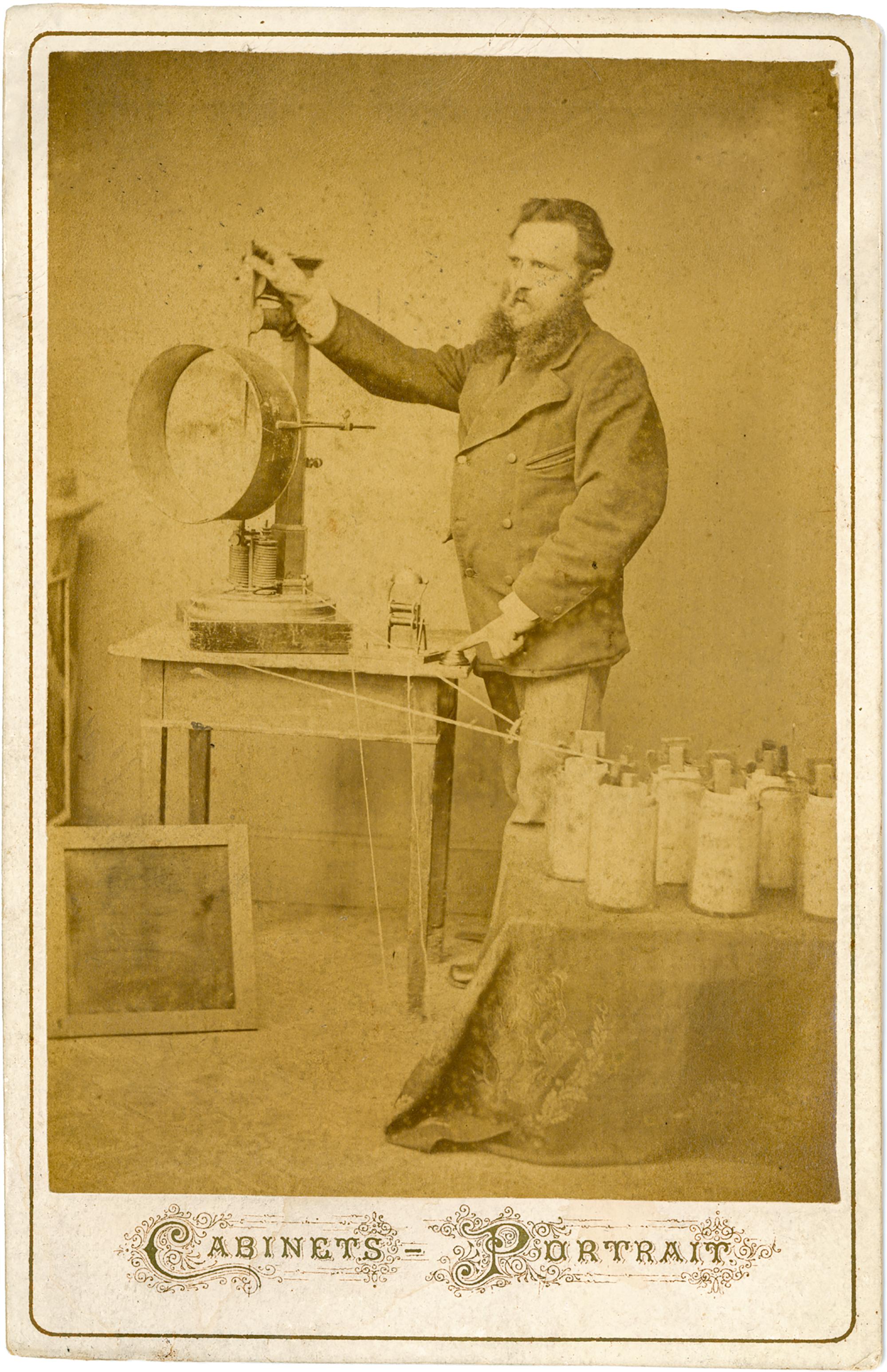 Fotografie im Kabinettformat von einem Beleuchter bei Circus Renz namens Karl Hempel mit einem Kohlenbogenscheinwerfer (1881).