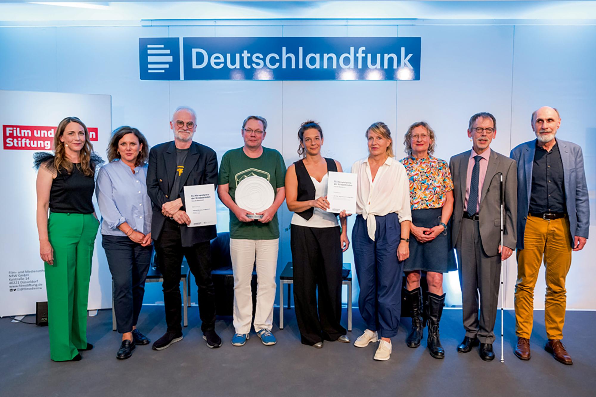 Moderatorin Ute Soldierer, Anke Morawe (Film- und Medienstiftung NRW), Werner Fritsch (nominiert), Preisträger Robert Schoen, Carina Pesch (nominiert), Antje Vauh (nominiert), Gabi Hartel (Juryvorsitzende), Klaus Hahn (DBSV), Dietrich Plückhahn (stellv. Vorsitzender)