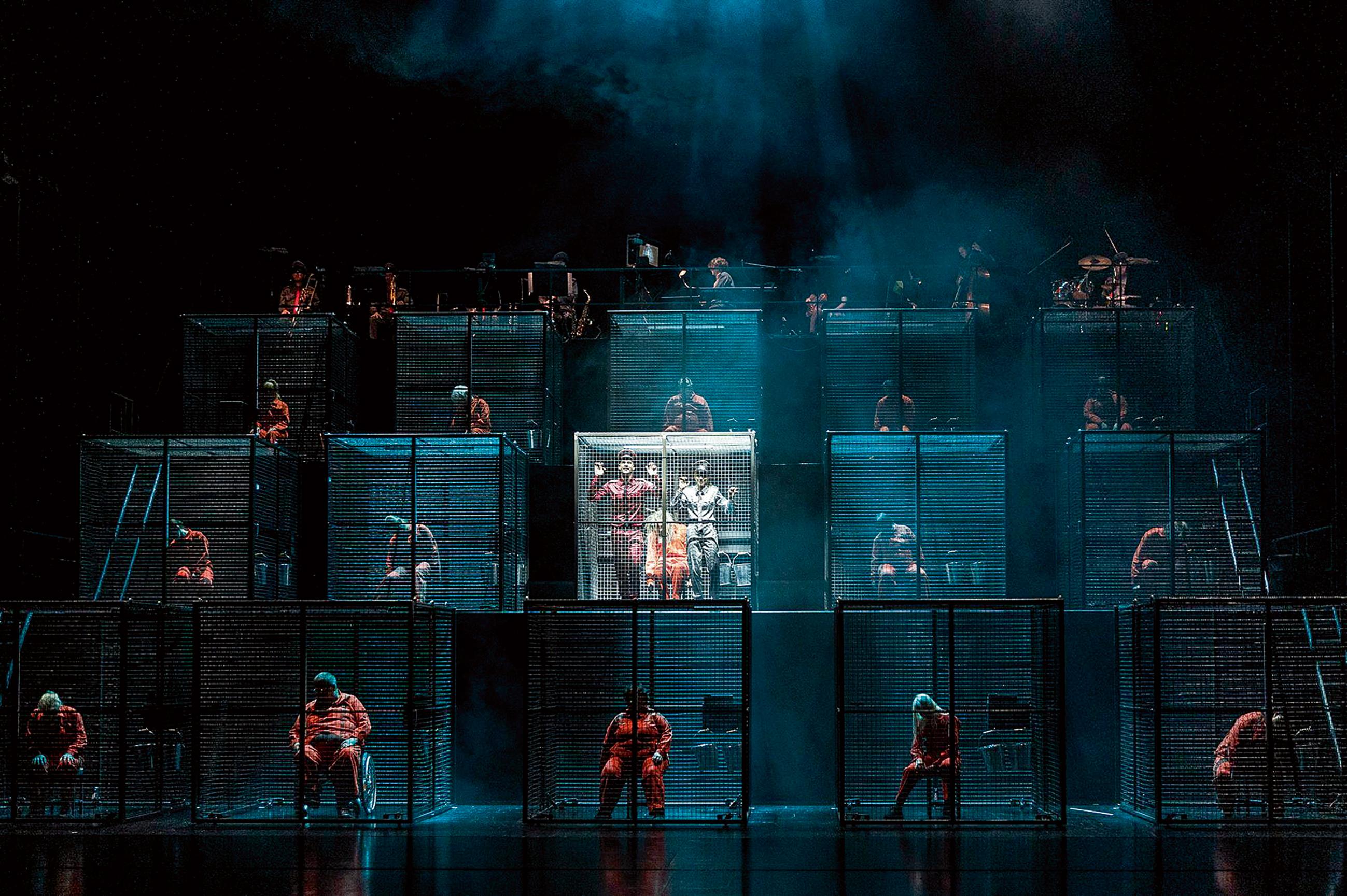 Gelsenkirchen hat keine Arbeit für alle. Aber ein einziger Job ist noch zu vergeben. Um den buhlen in Volker Löschs Musiktheater „Stadt der Arbeit“ die Massen in grauen Stahlkäfigen. Foto Isabel Machado Rio