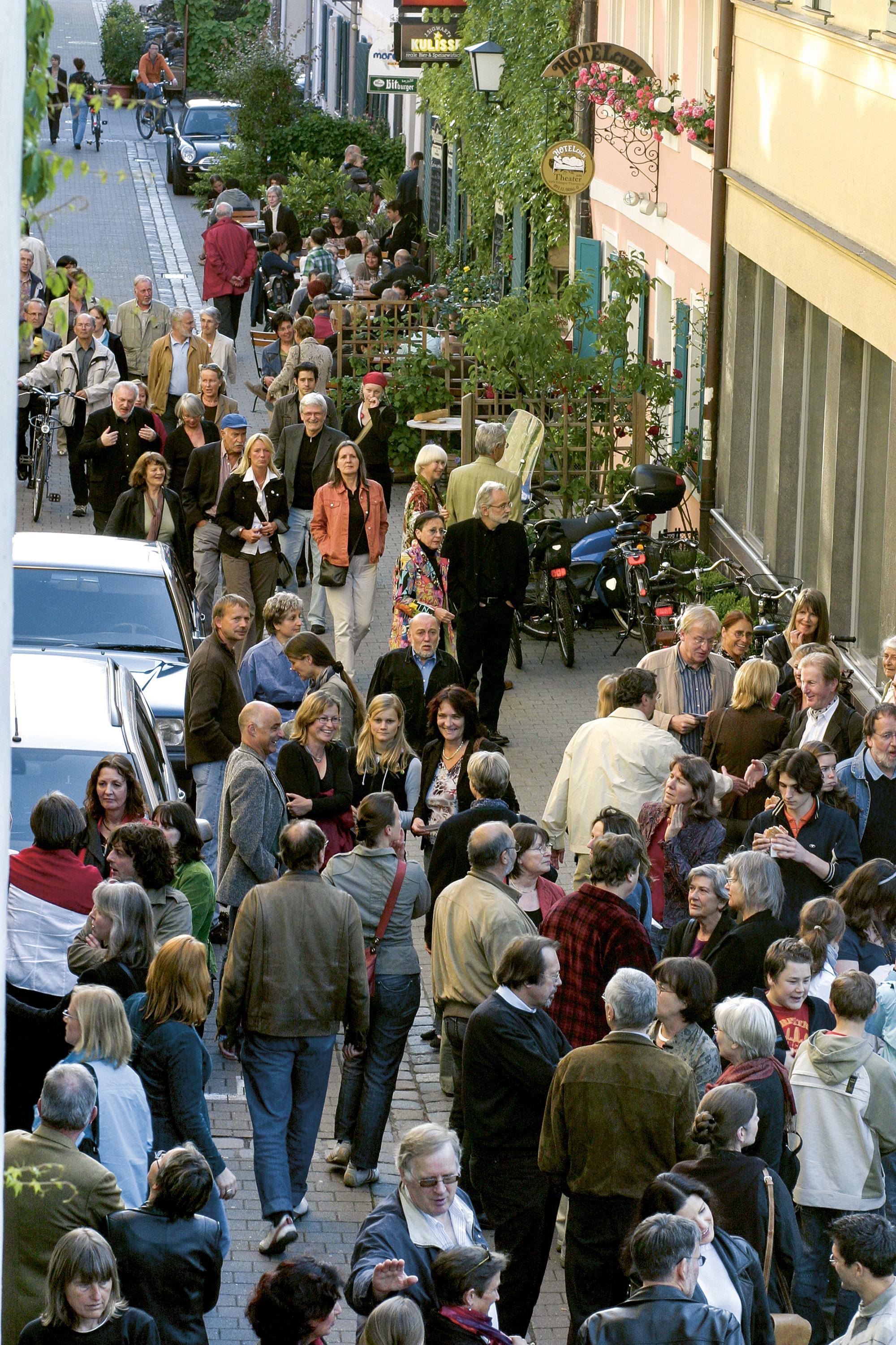 Festivalbesucher*innen flanieren auf der Erlanger Theaterstraße vor dem Hotelchen. 2007