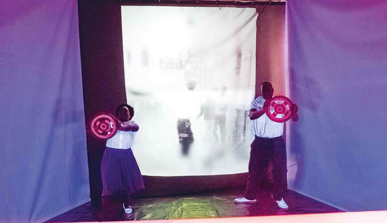 Zwei Performer*innen in der ihnen zugeteilten Aufgabe an der Station »Wet and Wild« in 3/Fifths – SupremacyLand, Foto: James Scruggs